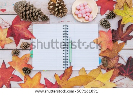 Notepad with colorful autumn leaves and color pencils. Workspace of artist, blogger, student.flat lay.