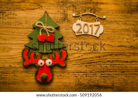 Merry Christmas with green vintage christmas tree and a reindeer. wooden Signboard with 2017 numbers
