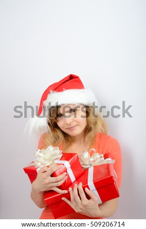 Girl in santa hat sitting by the fireplace with a gift box