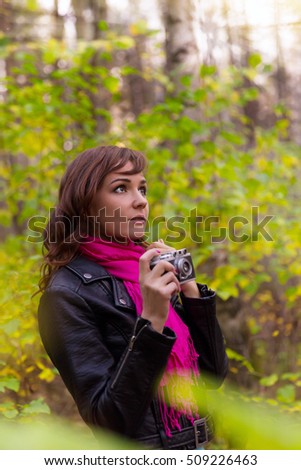Young brunette woman with a photo camera in autumn park