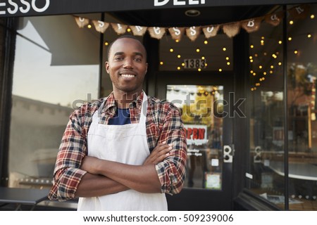 Black male business owner standing outside coffee shop Royalty-Free Stock Photo #509239006