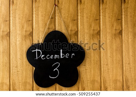 December 3, the inscription in chalk on the black chalkboard. Calendar on wooden background
