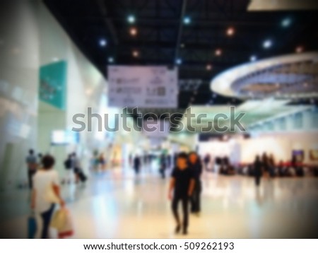 Blurry focus scene of people walking among the exhibition hall background atmosphere.