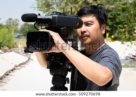 The cameraman filming outdoor event.