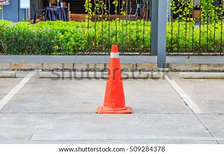 Orange Traffic Cone, traffic cone with white and orange stripes in parking lot.