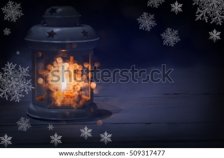 lantern with a candle inside in the dark and beautiful round balls of light around cute and delicate openwork snowflakes around Christmas holiday atmosphere and comfort. Dark picture with soft light
