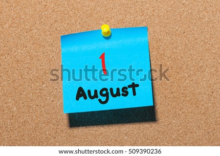 August 1st. Day 1 of month, color sticker calendar on notice board. Summer time. Close up