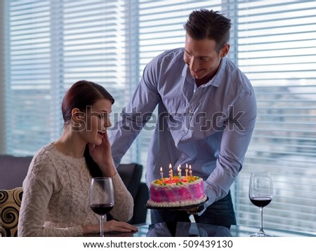 Mid adult man giving young woman birthday cake