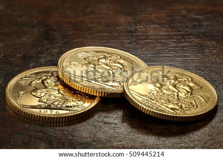 British Sovereign gold coins on rustic wooden background Royalty-Free Stock Photo #509445214