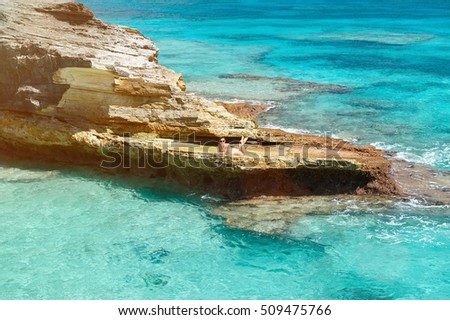 One woman lay on rock in caribbean clear blue water around