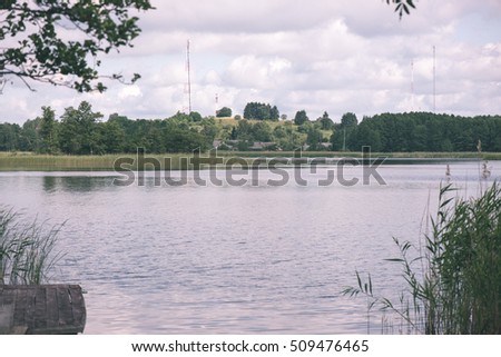Reflections in the calm lake water with dramatic clouds - vintage film look