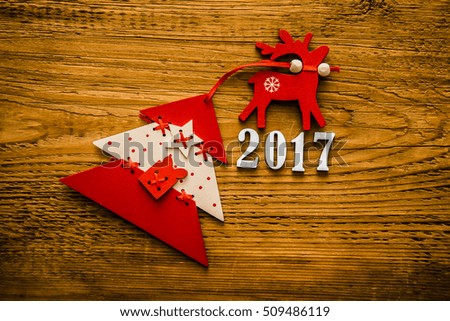 Wooden christmas tree, with white star and red deer and gift present box on a brown wooden background. 2017 happy new year