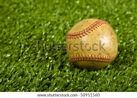 Baseball on green grass(artificial turf) used worn