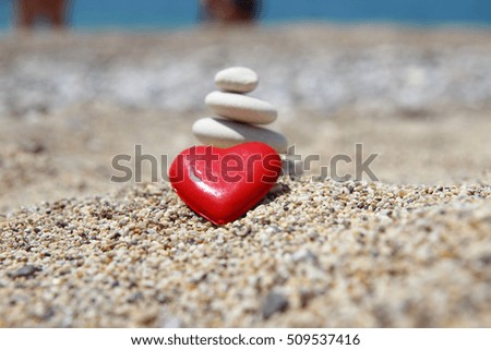 Red heart on sand beach