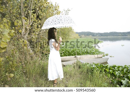 Portrait of beautiful young girl walking with umbrella