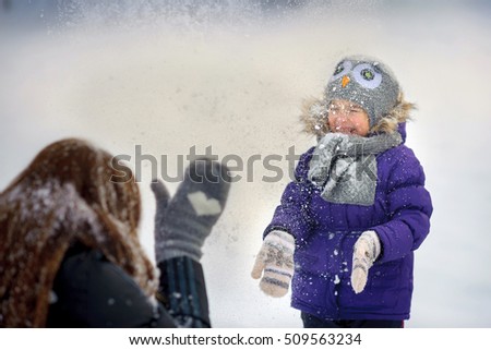 happy family plays on a snow glade, beautiful snow falls, a close-knit cheerful family, parents together with the daughter, on the eve of a holiday of Christmas, laugh and rush snow