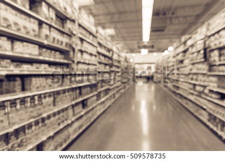 Blurred image of condiment, soup, pasta and canned vegetable aisle in store. Wide perspective view aisle, shelves with variety of products, defocused blurry background with bokeh light. Vintage filter