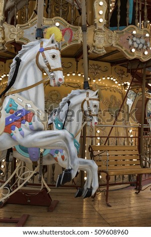  horse carousel, two rampant horses wood of a vintage carousel with lights and colors, game for children and family, front view