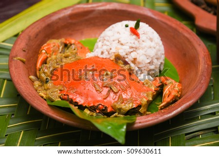 Chilli mud crab masala/curry with brown/red/matta rice, Kerala/Goa fish curry cuisine India. Hot and spicy seafood dish prepared using Indian spices on banana leaf. Mangrove/Black/Giant crustacean