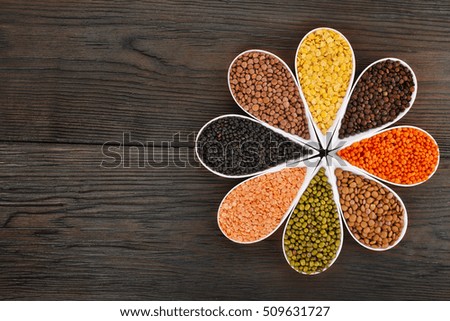 Bowls of various lentils on a wooden background