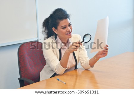 Business woman examine contract details by magnifier