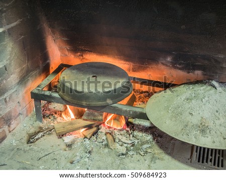 Picture of the stone bread oven stove with burning wood fire and red flames inside. Image of the burning wood fire against the background of the sooty wall.