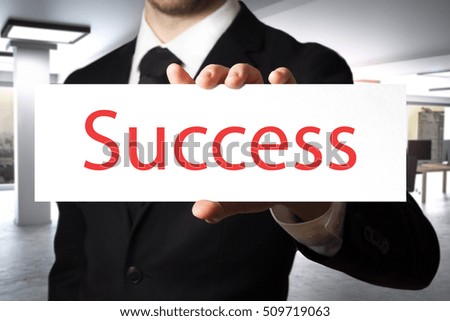 businessman in black suit showing sign success career