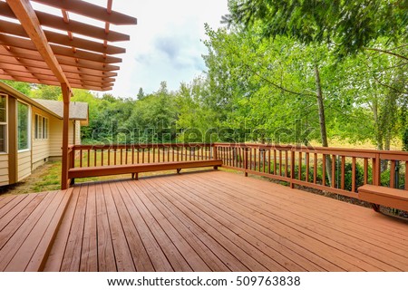 Exterior of horse ranch with empty wooden walkout deck.  Northwest, USA Royalty-Free Stock Photo #509763838