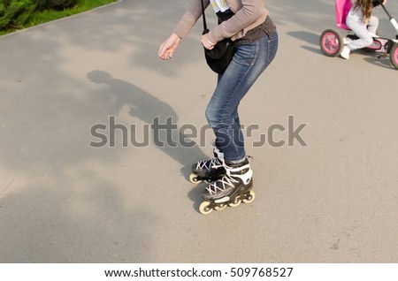 Young beautiful girl rollerblading in the park