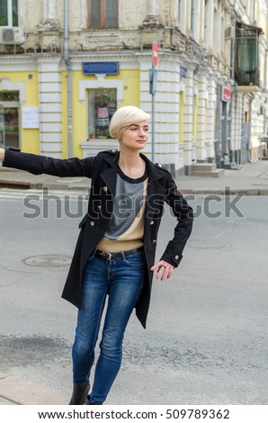 Young blonde girl walking on the city streets