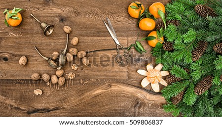 Orange mandarins, walnuts and antique accessories. Christmas tree branches on wooden background