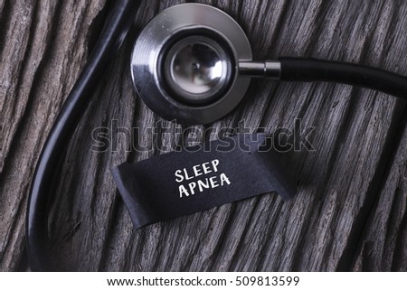 Medical Concept- SLEEP APNEA word written on label tag with Stethoscope on wood background