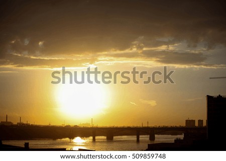Beautiful sunset over silhouette city skyline and river