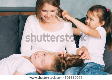 Family together happy. Mother with two daughters home relaxing playing. Family portrait.