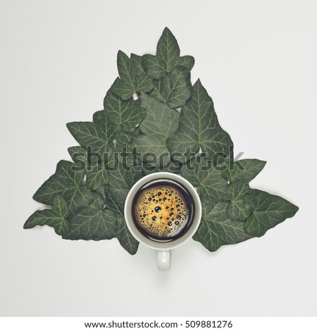 Perfect cup of coffee on white background with green leaves - Flat lay design