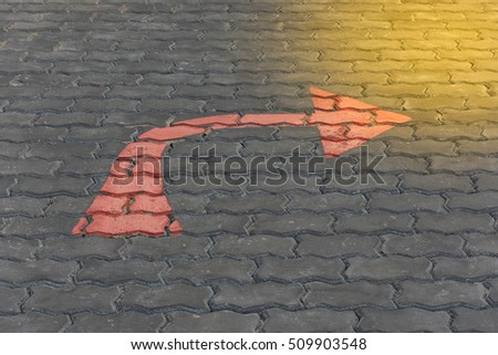 Arrow red sign paint on a brick road or walkway for turn right symbol , process in soft orange sun light style