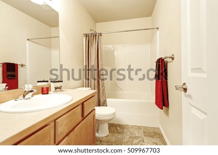 Bathroom interior in beige and brown colors. Wooden vanity cabinet with mirror, toilet and shower. Northwest, USA