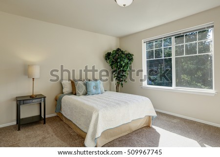Simply furnished bedroom interior with neatly arranged pillows on the bed and sunlight coming through the window. Northwest, USA