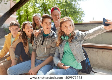 education, high school, technology and people concept - group of happy teenage students or friends taking selfie by smartphone