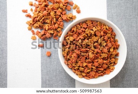 Dry cat foods over modern stripped tablecloth background