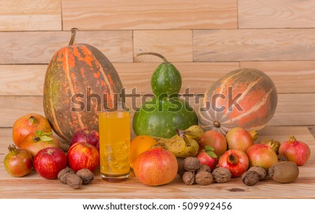 Autumn nature fruits concept. Fall fruits and orange juice, on a wooden table, studio picture