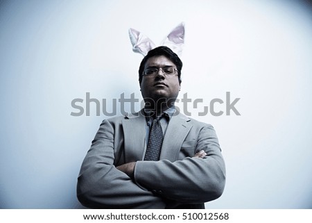 Studio portrait of businessman wearing bunny ears