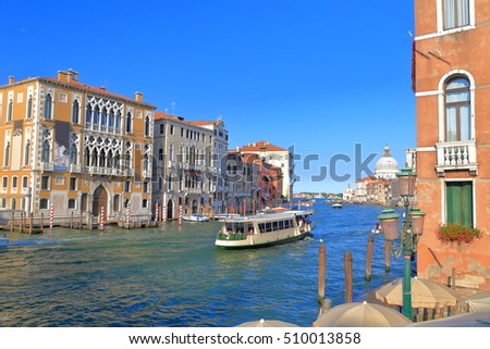 Tourist boat cruising along historical palaces on Grand Canal, Venice, Italy