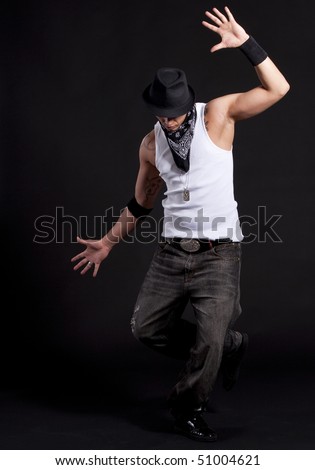 Young stylish asian dancer in front of black background moving to hip hop music.