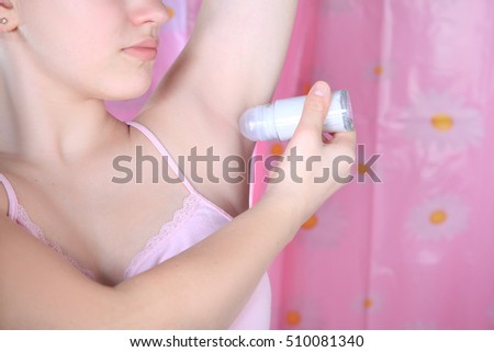 Girl in bathroom applying roll-on deodorant. Daily care body. Antiperspirants protection from sweat and unpleasant smell Royalty-Free Stock Photo #510081340