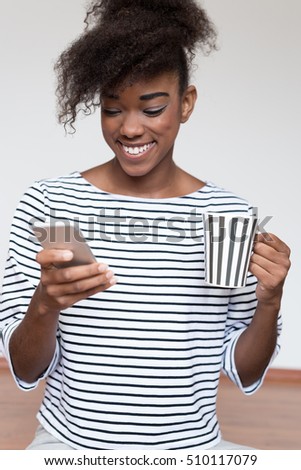 Close up portrait of a young  afro american woman enjoying cup of coffee