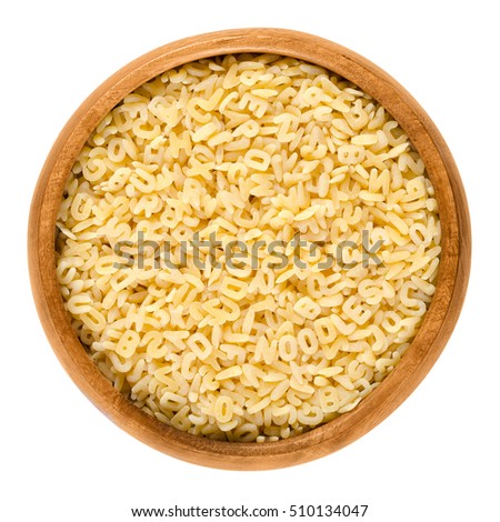 Alfabeto pasta in wooden bowl. Italian miniature noodles shaped as letters of the alphabet prepared with eggs. Uncooked dried durum wheat semolina pasta. Isolated food macro photo on white background. Royalty-Free Stock Photo #510134047