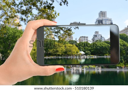 Tourist in Central Park of New York taking a shot at the beautiful landscape