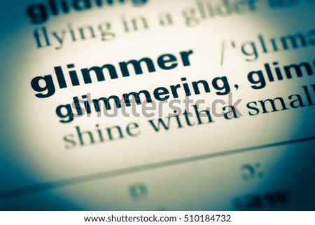 Close up of old English dictionary page with word glimmer