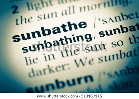 Close up of old English dictionary page with word sunbathe